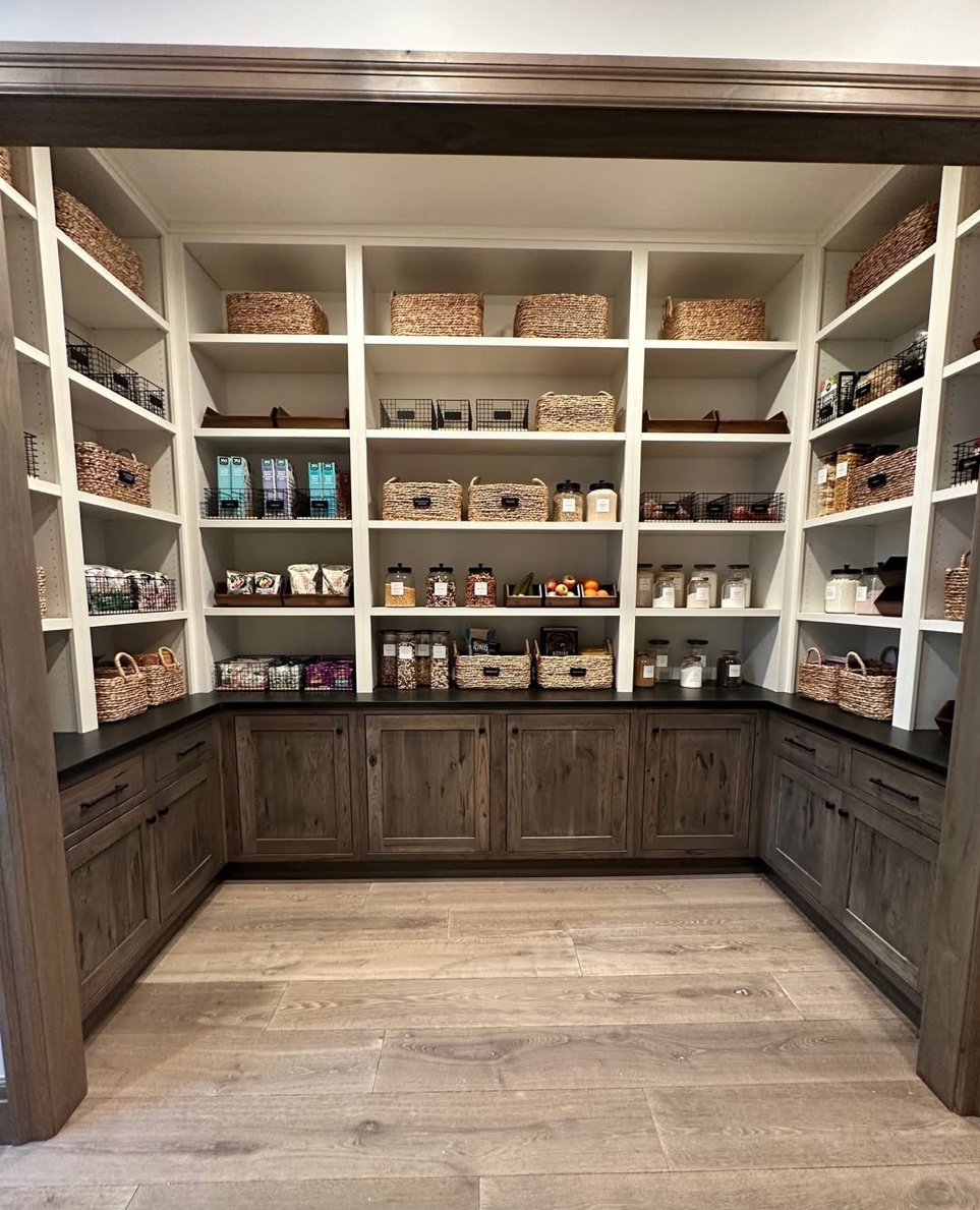 Rustic walk-in pantry with dark walnut cabinets and seagrass baskets, Cove Neck Long Island